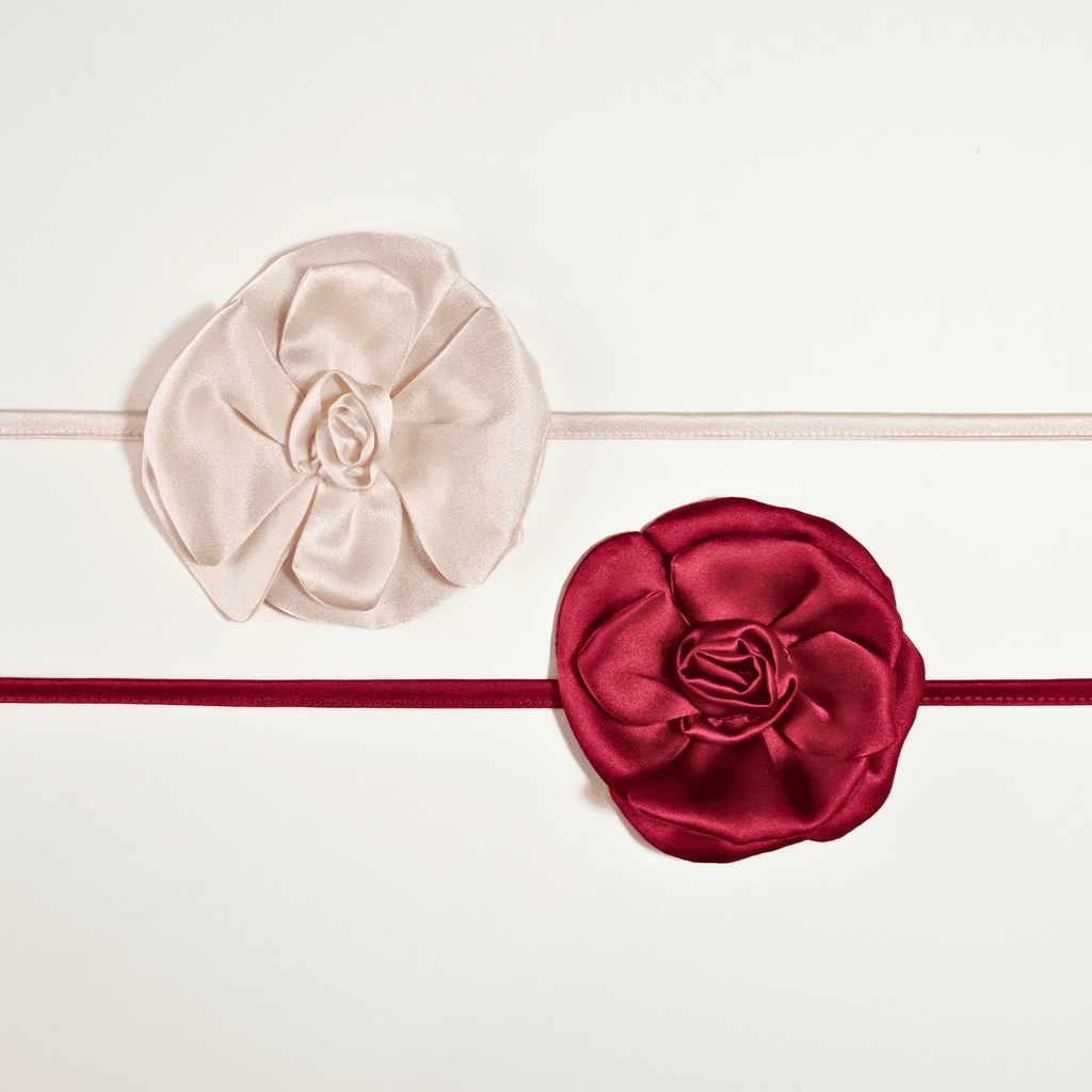 Collane choker Alkira Collection in raso di pura seta con fiore cucito a mano, nelle varianti colore bianco e burgundy, fotografate su sfondo bianco in vista dall’alto.