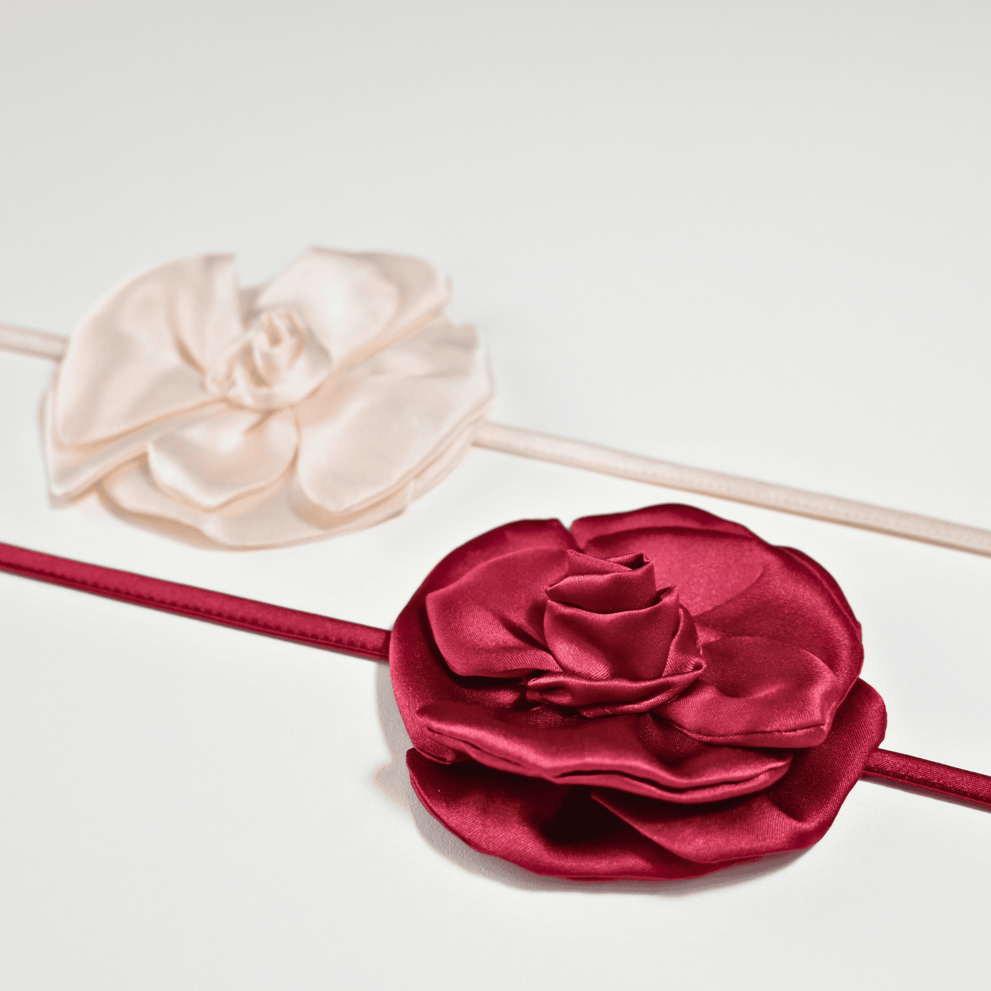 Collana choker da donna in raso di pura seta con fiore artigianale color rosso burgundy, cucito a mano petalo per petalo, stile elegante firmato Alkira Collection, ideale per occasioni serali. Foto su sfondo bianco con angolazione laterale.