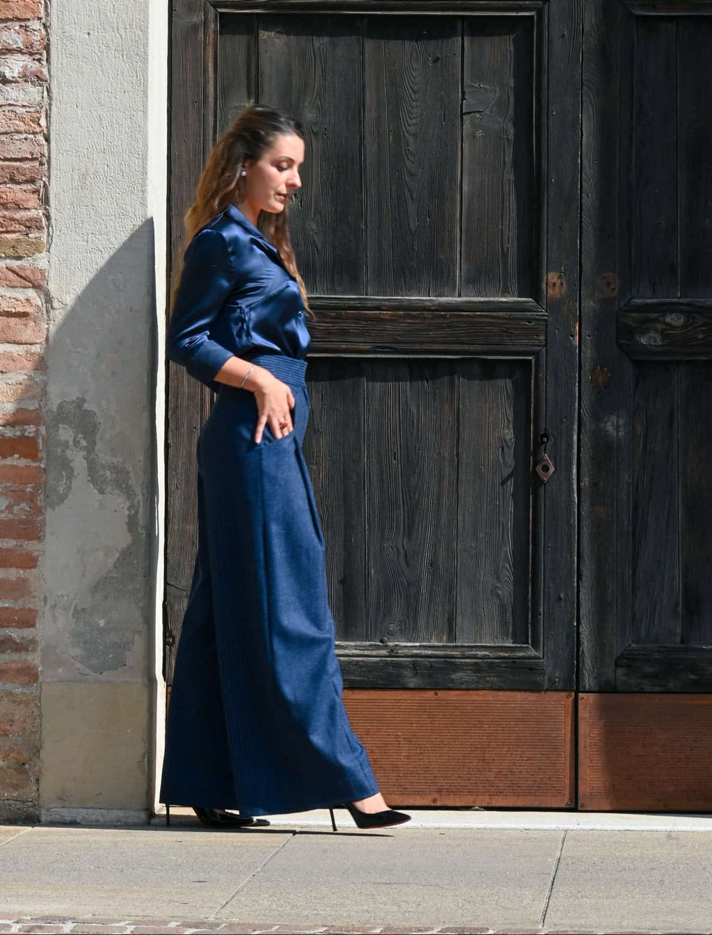 pantalone in lana gessata blu  indossato da modella mentre cammina e si vede ampiezza ella gamba 