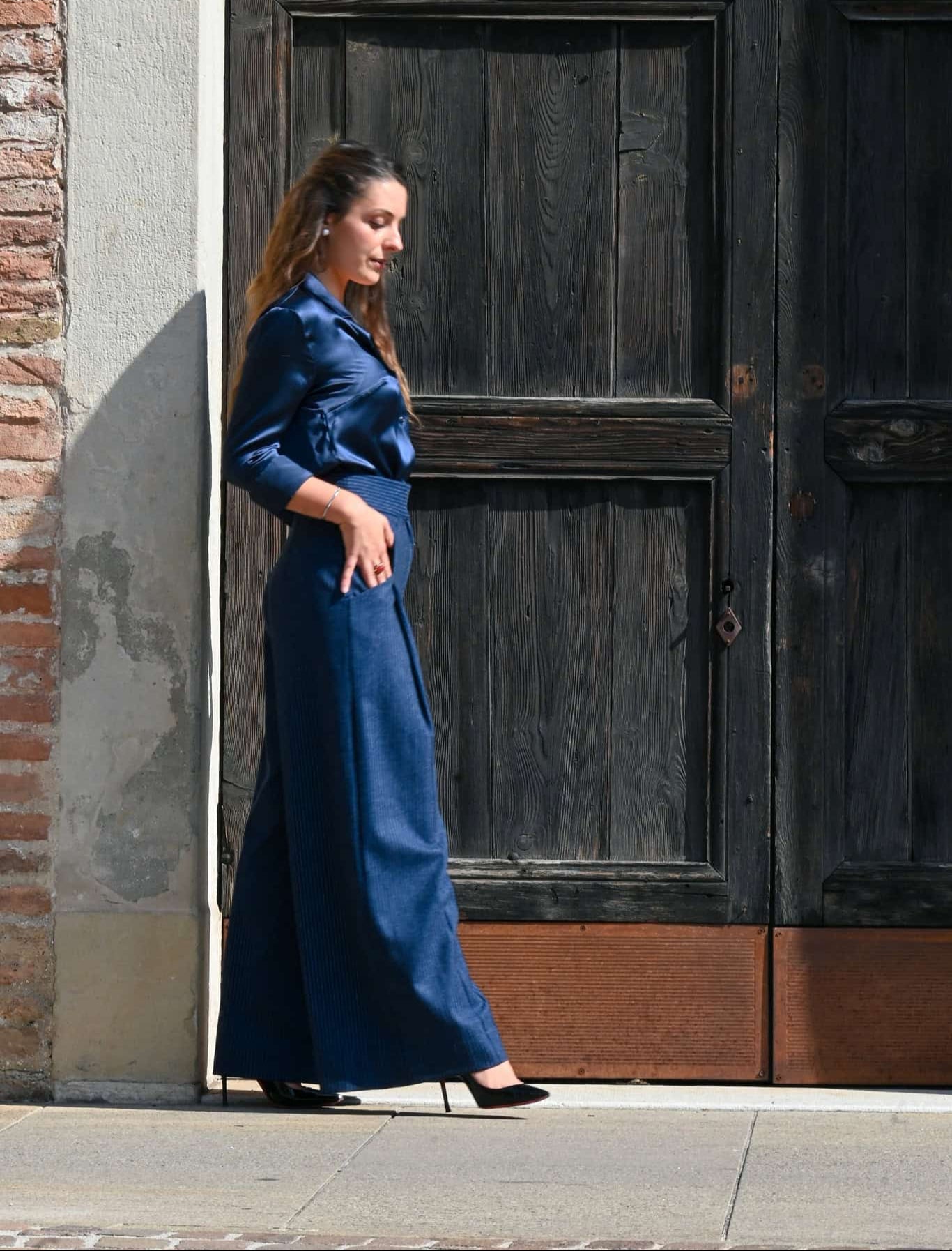 pantalone in lana gessata blu  indossato da modella mentre cammina e si vede ampiezza ella gamba 