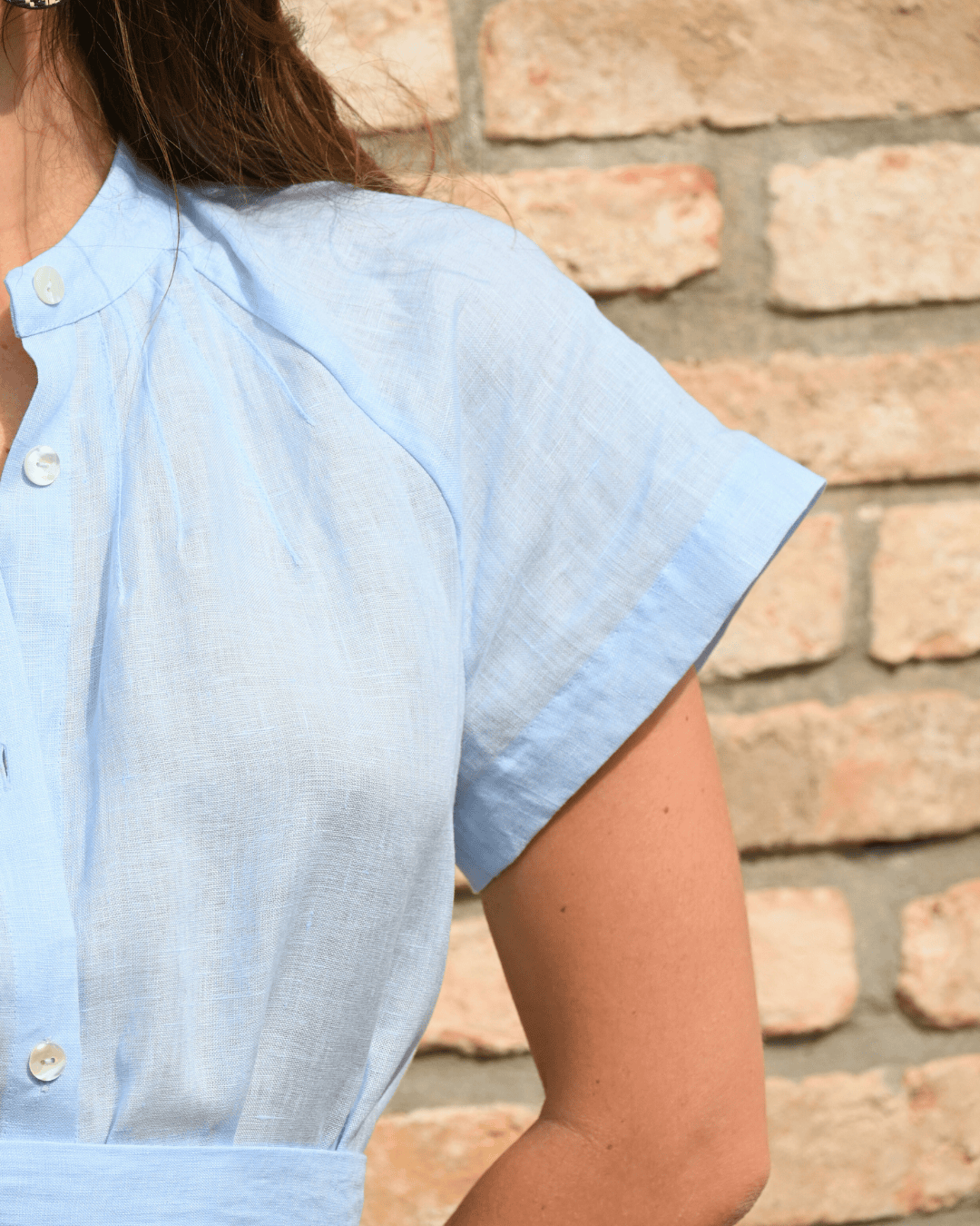 Detaglio di manica con cucitura pulita e di qualitá. Vestito in lino azzurro da donna, Ideale per un look estivo e versatile, riflette la qualità del lino Made in Italy.