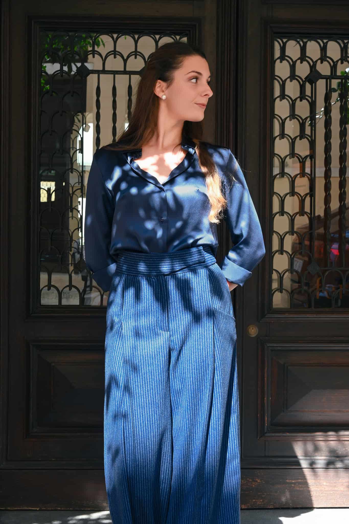 pantalone blu in lana gessata abbinato a camicia blu in seta indossato da modella 